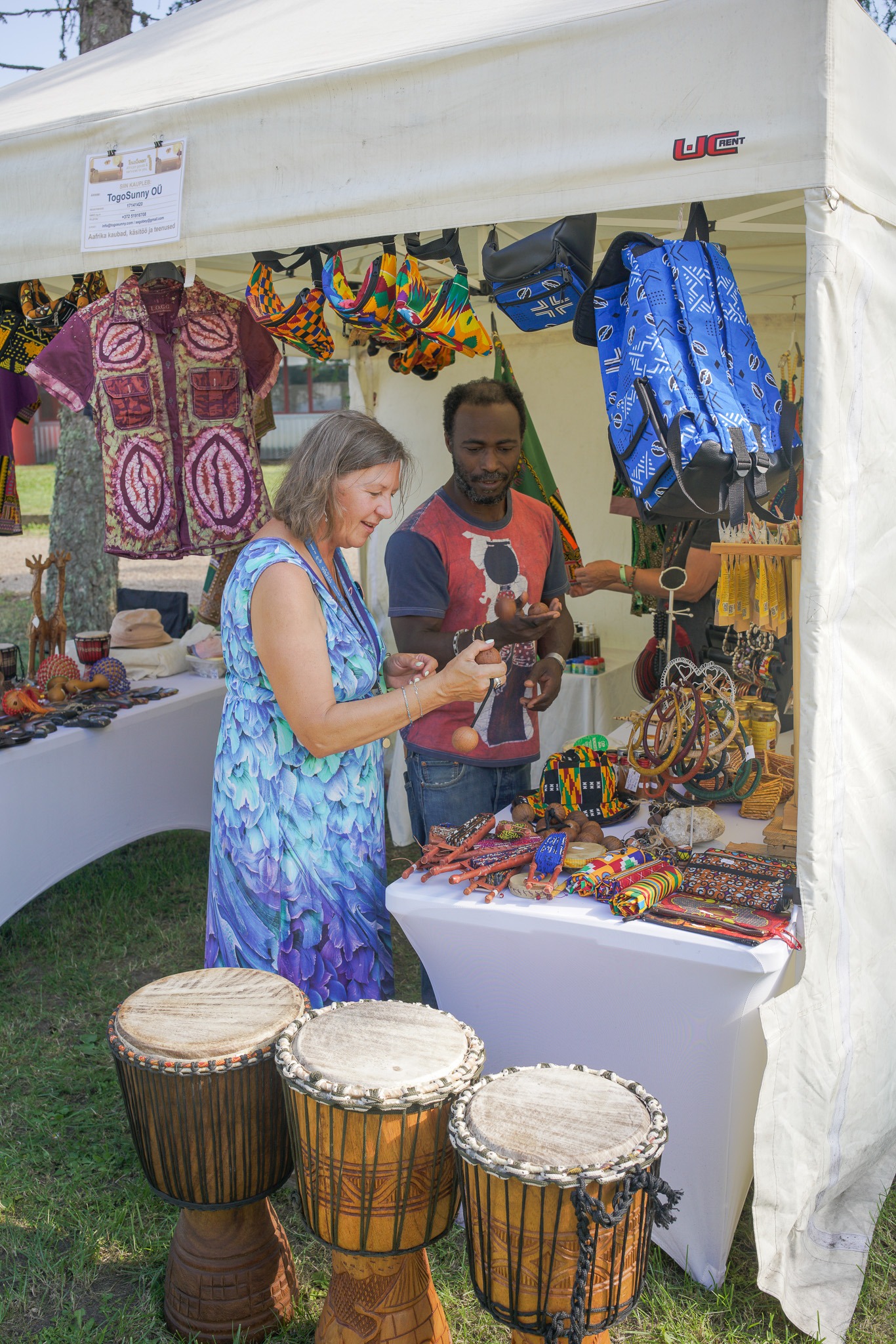 A visitor tries a maraca at the TogoSunny stand, in bright sunlight