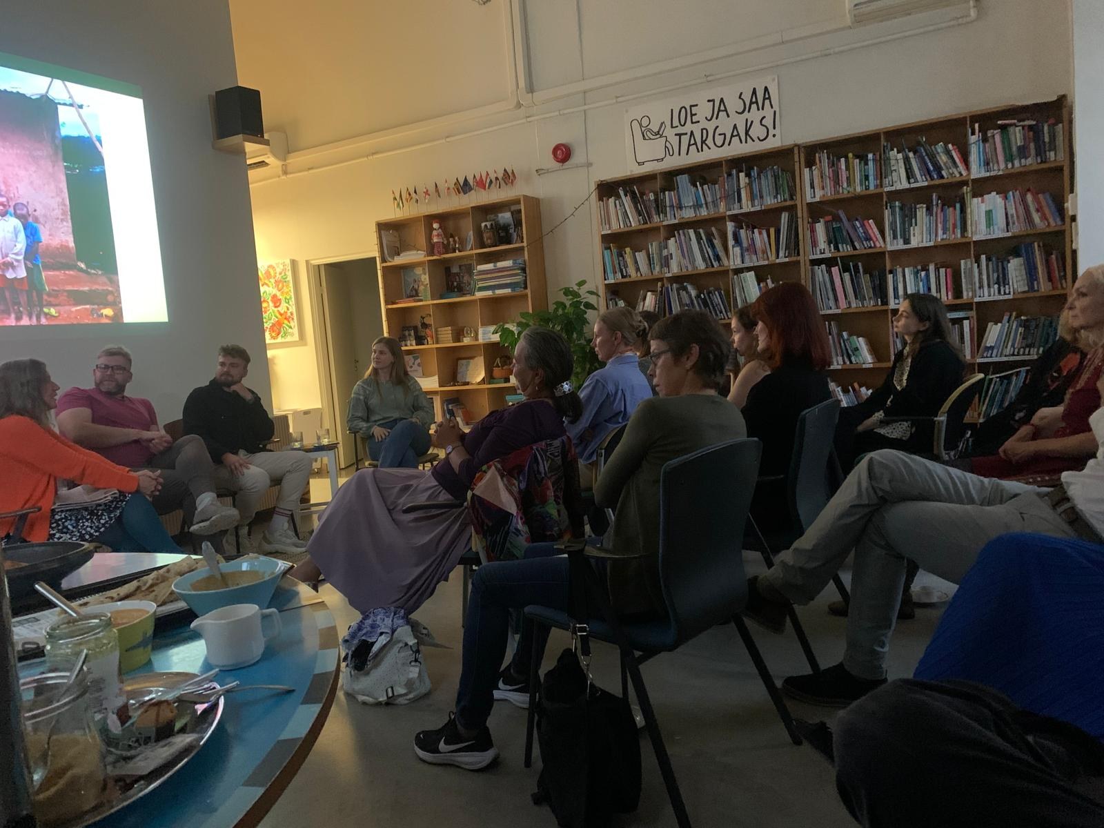 Audience listening as travel photos are projected on the wall