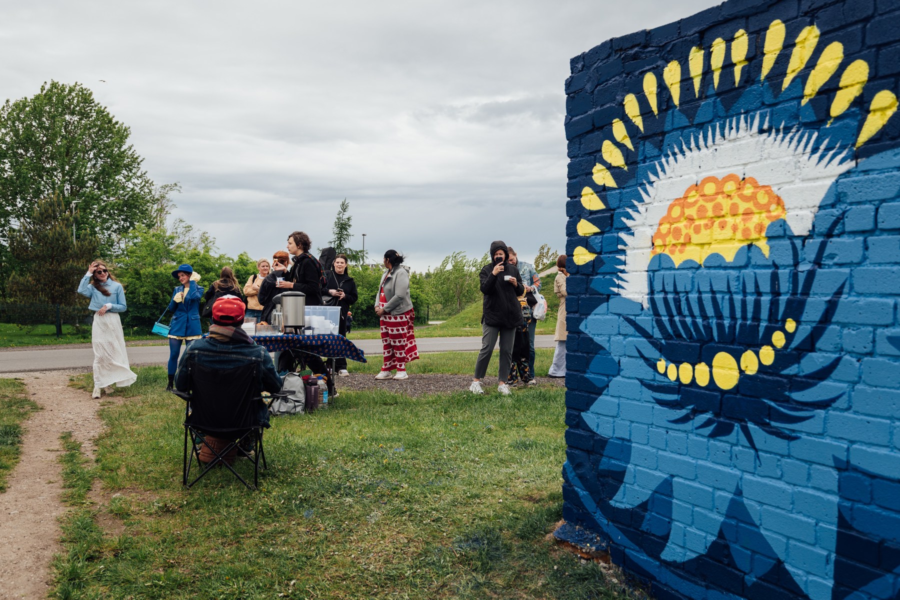 View of the blue street art piece and the chatting crowd