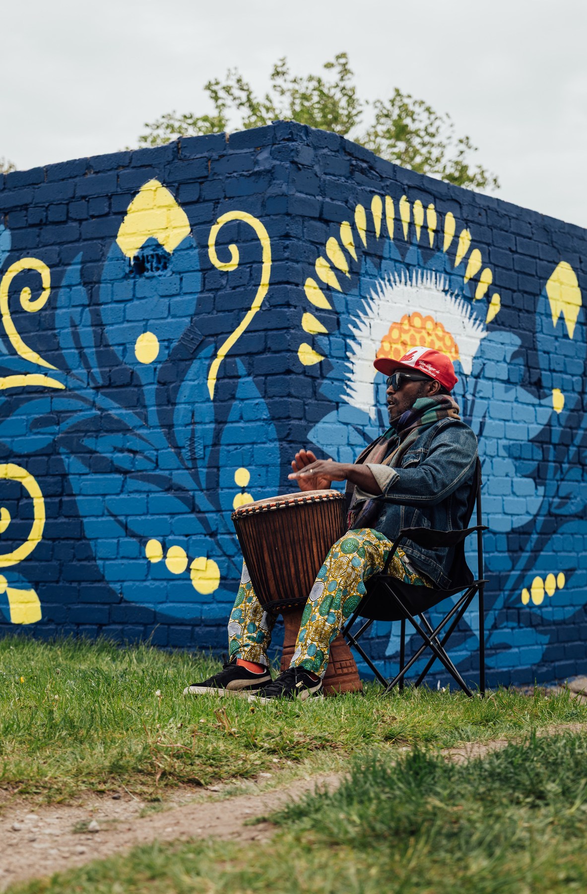 Senam Tsogbe playing djembe alone at the corner of the wall