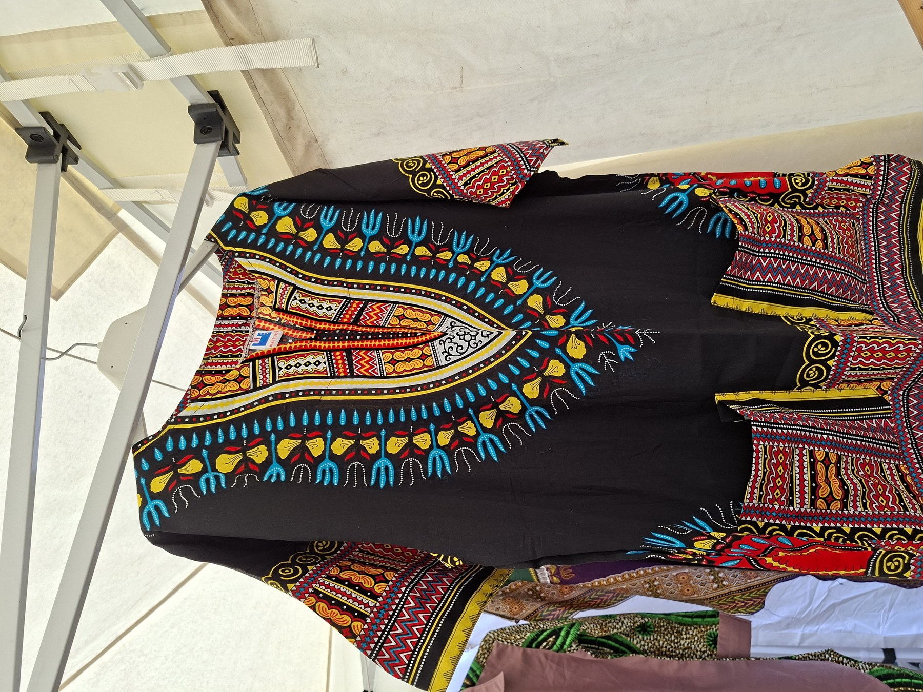 Black dashiki garment with colourful wax print pattern