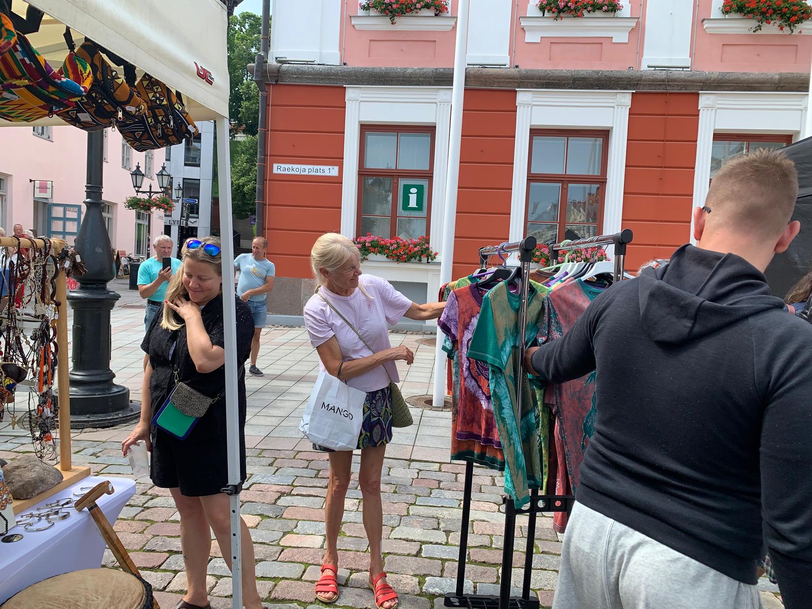 Two visitors browsing batik shirts on Raekoja plats