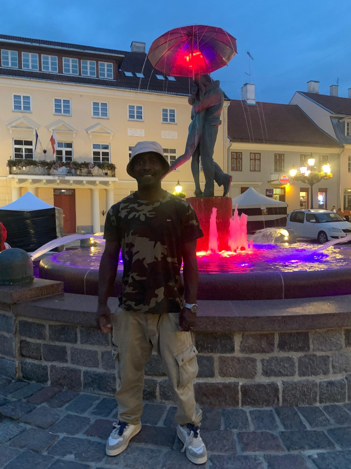 The TogoSunny seller by the fountain lit red in the evening