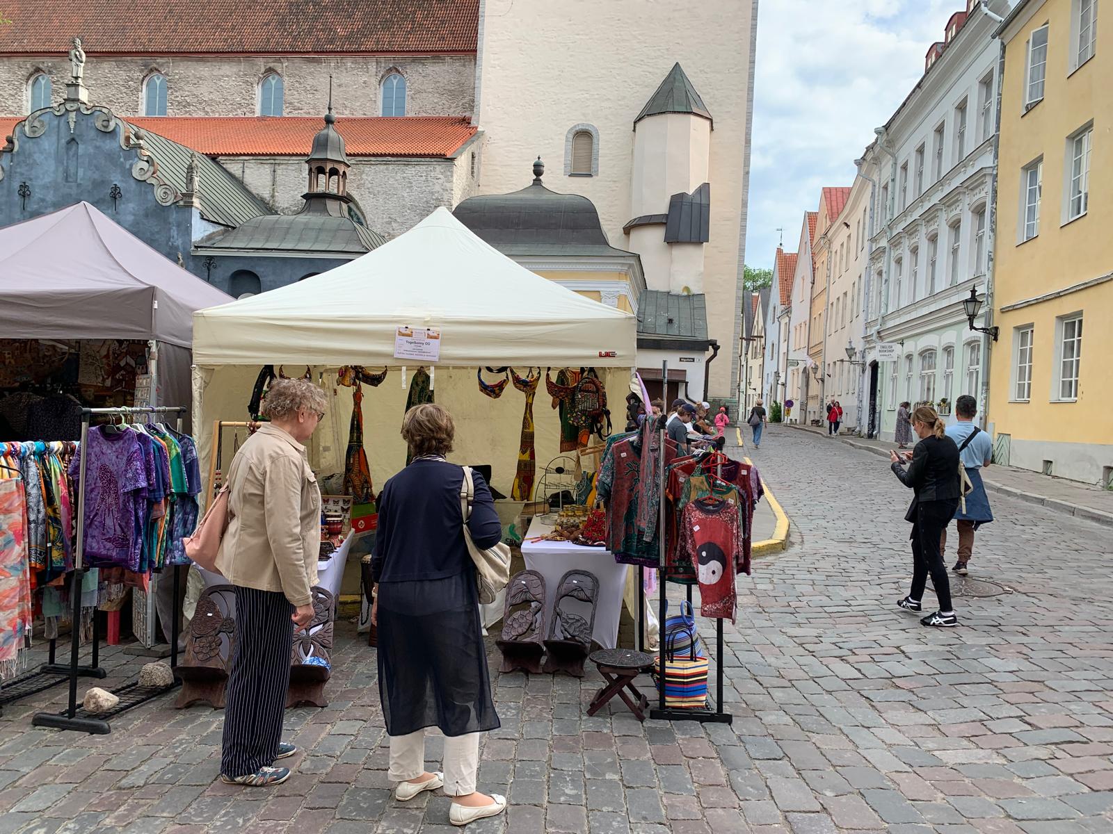 TogoSunny tent beside St Nicholas' Church with visitors and a passing car