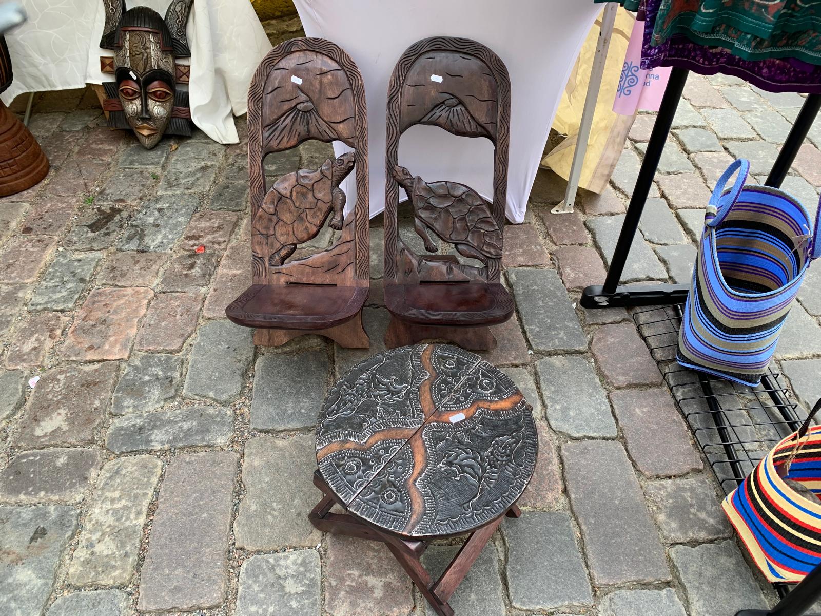 Hand-carved wooden turtle chairs and an engraved folding table
